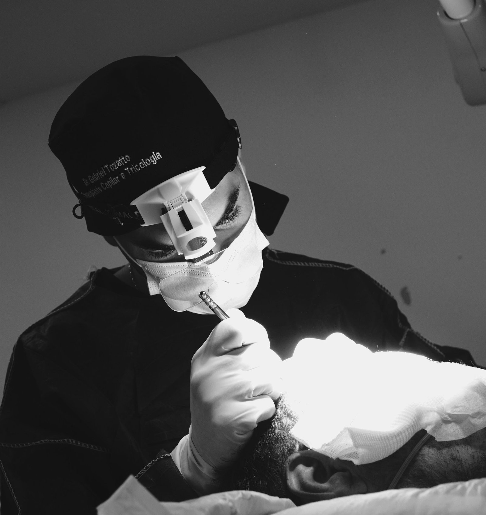 Dr. Gabriel Tozatto realizando transplante capilar no Espírito Santo, com lupa cirúrgica